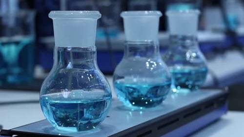 Blue Liquids Stirring in Glass Beakers