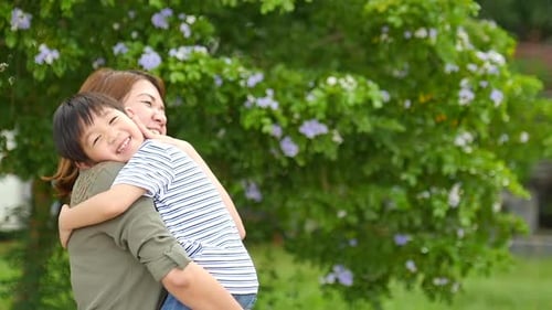 Happy Asian Mother Playing With Her Son In The Park