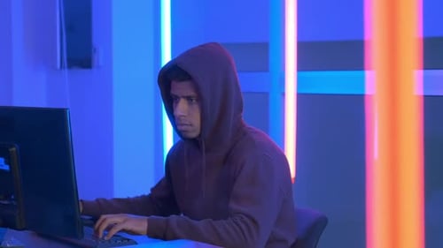 Afrikanischer Hacker im Hoodie bei der Arbeit am Computer