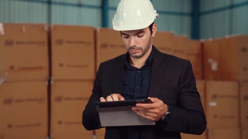 Factory Manager Using Tablet Computer in Warehouse or Factory