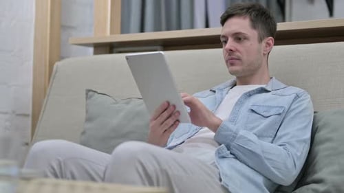 Adult Relaxing at Home with Tablet Device