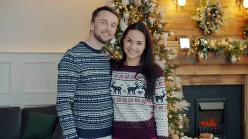 Happy Couple Posing by Christmas Tree Fireplace at Home