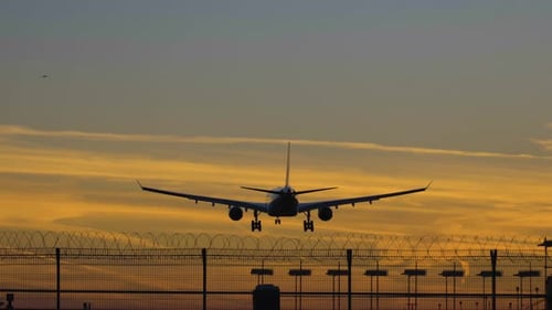 Silhouette einer Flugzeuglandung am Flughafen bei buntem Sonnenuntergang