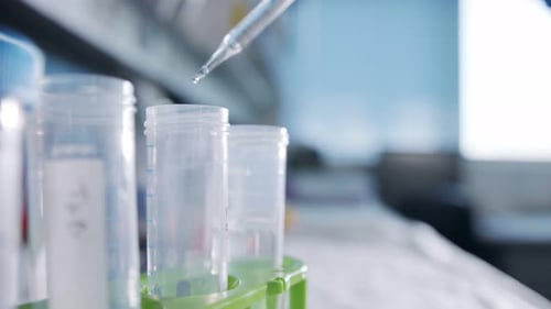 Slow motion macro shot of drop falling into a test tube in a laboratory