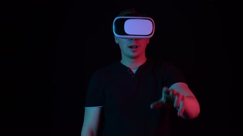 Young Adult Using Virtual Reality Headset in Dark Room