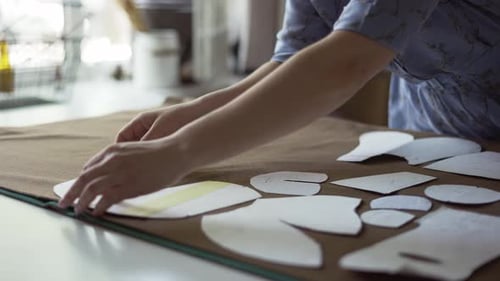 Woman Arranging Sewing Pattern Pieces on Fabric