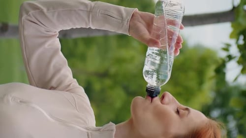 Woman Drinks Water Bottle Outdoors Close Up
