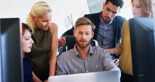 Team Collaboration Around Computer in Modern Office