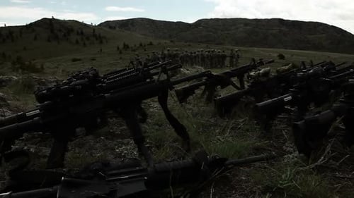 Sturmgewehre im Vordergrund mit einer Gruppe von Soldaten im Hintergrund.