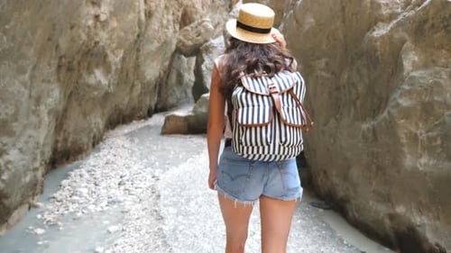 Unerkennbare junge Frau mit Rucksack, die über den Narrow Canyon geht. Wanderer mit Hut beim Bummeln