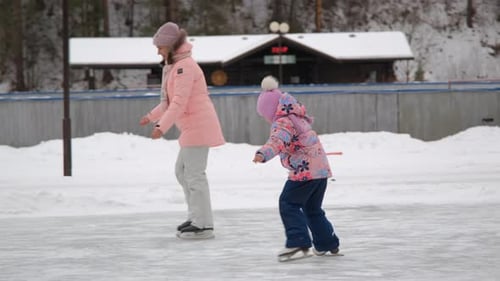 Woman with Little Daughter Ice Skating Outdoors