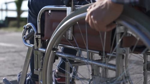 Man in Wheelchair Turning Wheels Outside