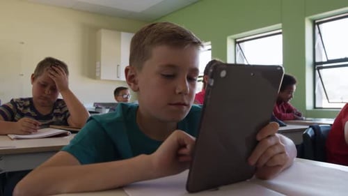 Junge benutzt digitales Tablet in der Klasse