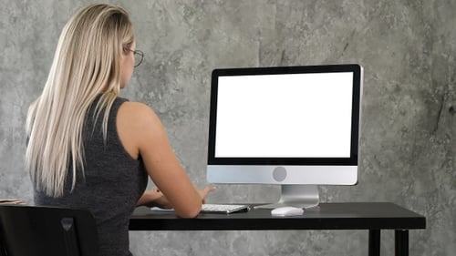 Young business woman working in office interior on pc on