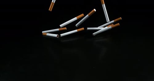 Cigarettes Falling against Black Background, Slow Motion 4K