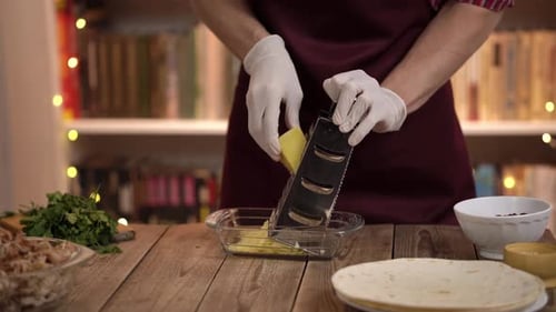 Chef of Restaurant in Form Prepares Food on Table Grate Cheese for Salad and Prepare Enchilada