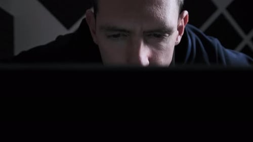 Man Looking Intently at Computer Screen at Night