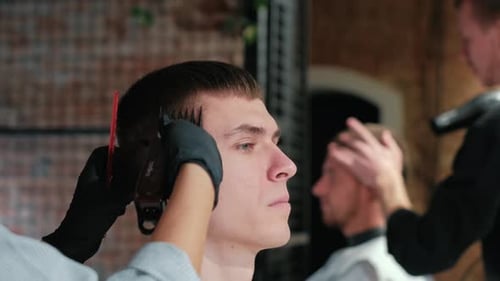 Männlicher Haarschnitt mit Elektrorasierer. Nahaufnahme der Haarschneider-Frisur. Professioneller Friseur