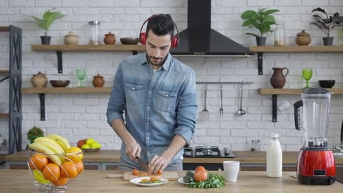 Man Cooking, Dancing, and Chopping Vegetables at Home