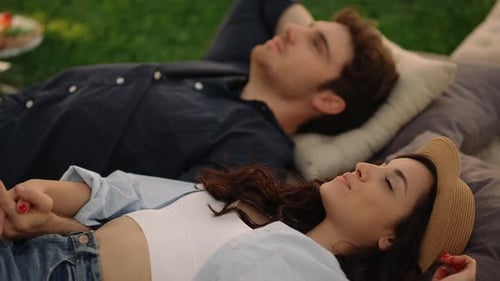 Young Couple Lying Together on Grass Outdoors