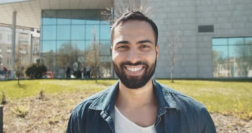 Smiling Young Adult Man Outside a Modern Building