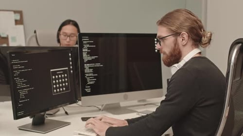 Developers Coding on Computers in Modern Office