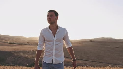 Horizonte de campo infinito e homem andando no brilho do sol médio no fundo