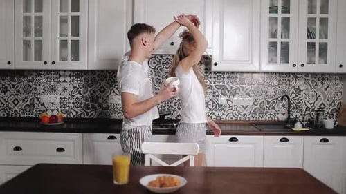 Romantic Couple Dancing in Kitchen in Matching Pajamas