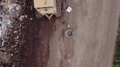 Bulldozer Compacts Waste at Urban Landfill Site