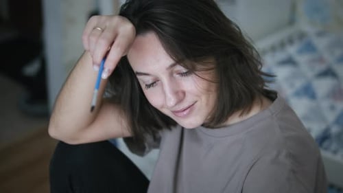 Woman Concentrates on Art Project at Home