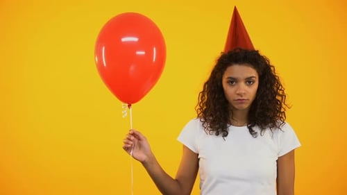 Sad Woman in Party Hat Holding Balloon