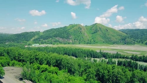 Aerial Flying Over the Mountains and the Forest Under the Cloudy Sky
