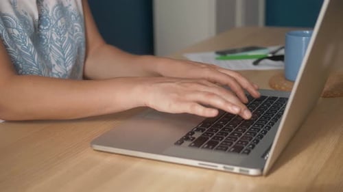 Young Happy Woman Sits in Bright Apartment or Office Interior and Works at a Laptop, Freelancer Girl