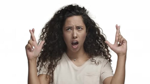 Closeup de uma atraente modelo hispânica com penteado comprido escuro que parece esperançosa e cruzada