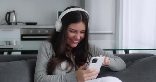 Entspannte junge Frau nutzt Smartphone Surfen in sozialen Medien Nachrichten beim Spielen von Handyspielen oder