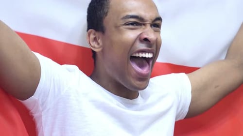 Excited Man Celebrates With Flag and Raised Arms
