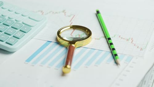 Documents with Magnifying Glass and Calculator