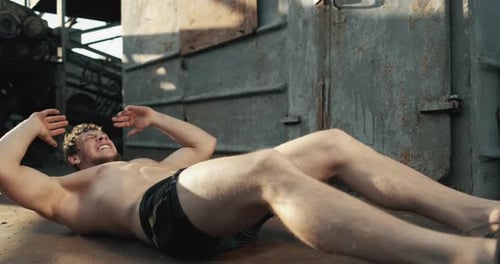 Muscular Man Does Sit-Ups in Industrial Gym