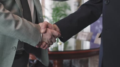 Businessmen Handshake at Office in Suits