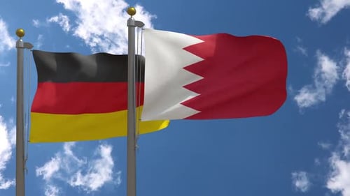 Flags of Germany and Bahrain Waving Side-by-Side in Blue Sky