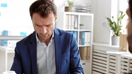 Serious Man Talking in Office Workplace Drinking Coffee