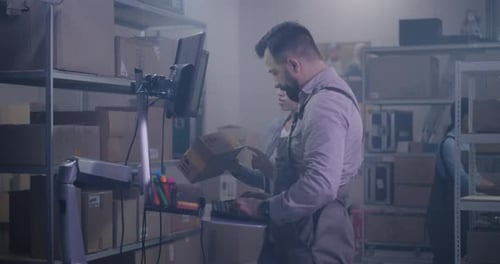 Mann überprüft Paket mit Barcodescanner