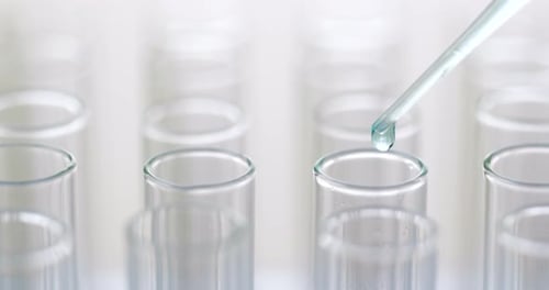 Adding Liquid to Test Tubes in a Laboratory