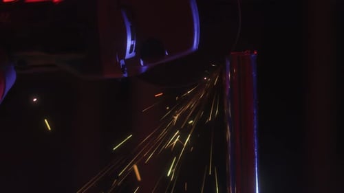 Grinder sparks while cutting metal pole in the dark