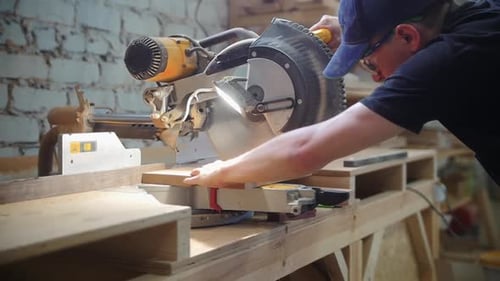 Carpentry Workshop Man Worker Cutting on the Wooden Desk Using a Big Circular Saw