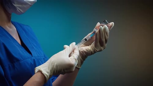 Healthcare Worker Preparing Injection Syringe in Hospital