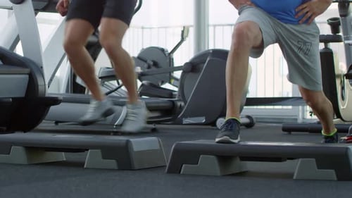 Hommes effectuant des fentes de saut dans la salle de gym