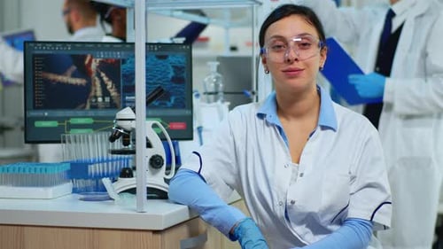 Woman Smiling in Lab with Microscope and Tubes