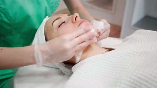 Woman Receiving Facial with Cotton Pads in Spa