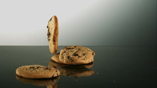 Chocolate Chip Cookies Falling onto a Reflective Surface